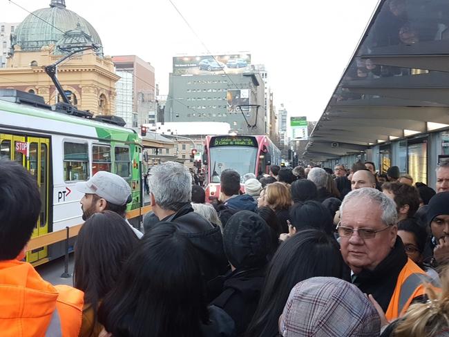 People cram at a tram stop outside Flinders St station. Picture: Twitter/lamourette folly