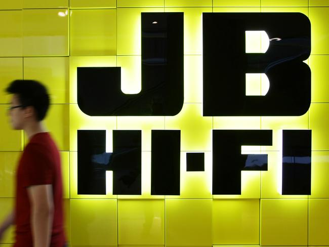 A man walks past a JB Hi-Fi Ltd. logo displayed outside a store in Sydney, Australia, on Monday, Feb. 13, 2012. JB Hi-Fi is Australia's second-largest electrical retailer. Photographer: Brendon Thorne/Bloomberg