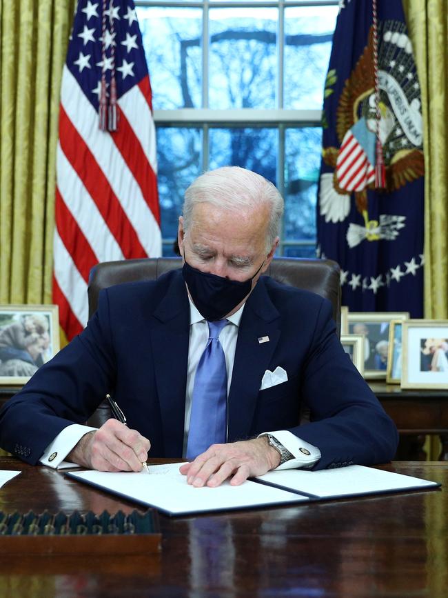 US President Joe Biden signs executive orders in the Oval Office. Picture: Reuters