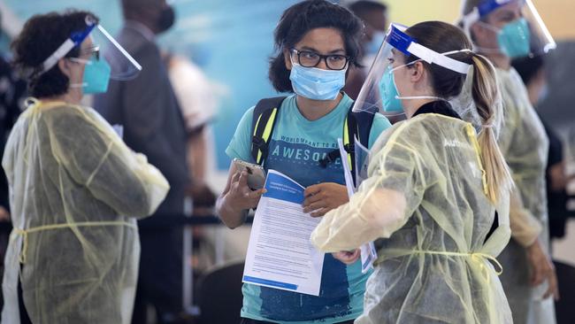 Passengers from a Sydney flight are met by DHHS staff at Melbourne Airport. Picture: David Geraghty