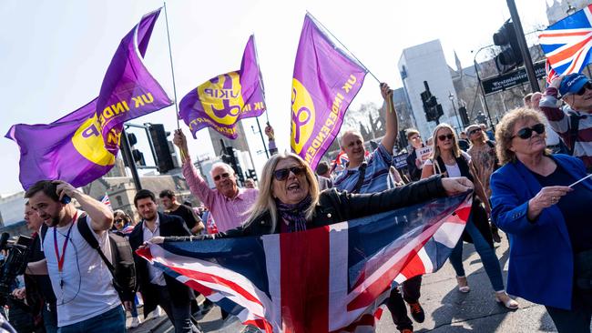 Pro-Brexit demonstrators wave flags as protesters gather in Parliament Square in central London on Friday.