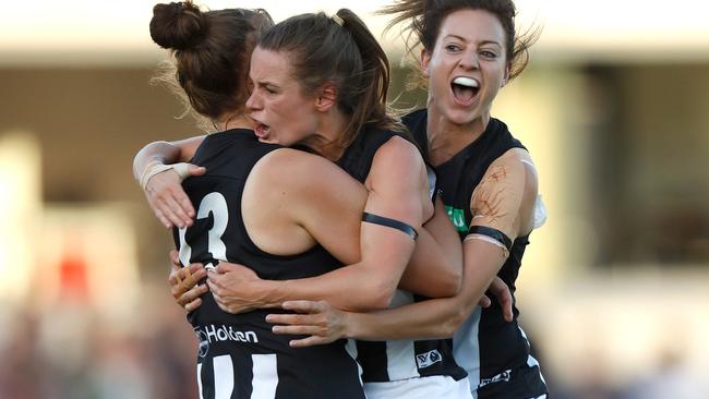 Jasmine Garner is congratulated by Alicia Eva and Stephanie Chiocci after kicking the first goal in AFLW history.