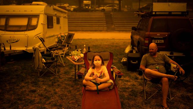 Amy (L) and Ben Spencer sit at the showgrounds in the southern New South Wales town of Bega after they were evacuated from nearby sites affected by bushfires. Picture: AFP.