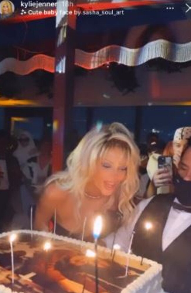 Kendall blew out her candles as a worker, who was masked, held the cake