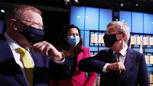 IOC president Thomas Bach, right, bumps elbows AOC president John Coates as Queensland Premier Annastacia Palaszczuk looks on. Picture: AFP