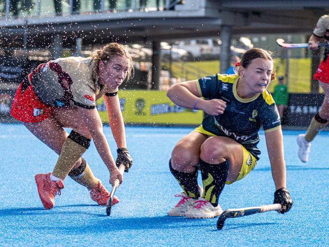 Tigers player Philly Bridley cops some spray as she competes for possession with a NSW rival. Picture: Liam Boric/Liberty Hockey One League