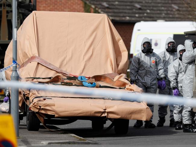 British military personnel wearing protective coveralls work to remove a vehicle connected to the March 4 nerve agent attack in Salisbury.