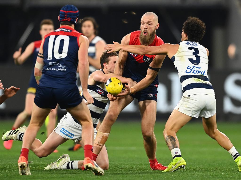 Max Gawn attempts to handball while being tackled by two Cats. (Photo by Quinn Rooney/Getty Images)