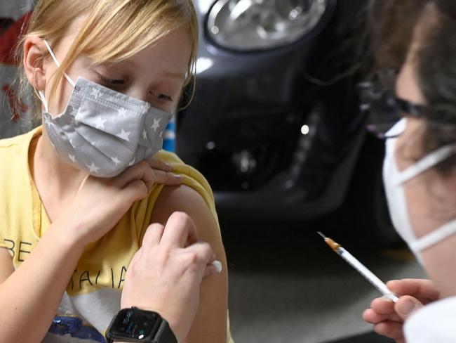 Six-year-old Hanna is inoculated with the Pfizer BioNTech vaccine for children  at a vaccination centre set up at a car dealership in Iserlohn, western Germany, on January 5, 2022, amid the ongoing coronavirus (Covid-19) pandemic. - The owner of the car dealership, Arne Olsen, has temporarily set up a vaccination centre with a team of doctors and nurses at his dealership and has had several hundred people vaccinated since the start in December. As many people as possible are to be vaccinated by the second week of January. (Photo by Ina FASSBENDER / AFP)