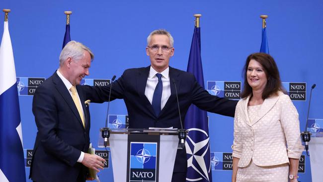 NATO Secretary General Jens Stoltenberg (C) embraces Finnish Foreign Minister Pekka Haavisto (L) and Swedish Ministry for Foreign Affairs Ann Linde after the signing of the accession protocols of Finland and Sweden at the NATO headquarters in Brussels on July 5.