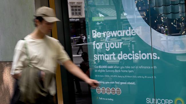 A man walks past a bank advertising home loans. Had the RBA people been on the ground around Australia, they would have lifted interest rates much earlier. Picture: AFP