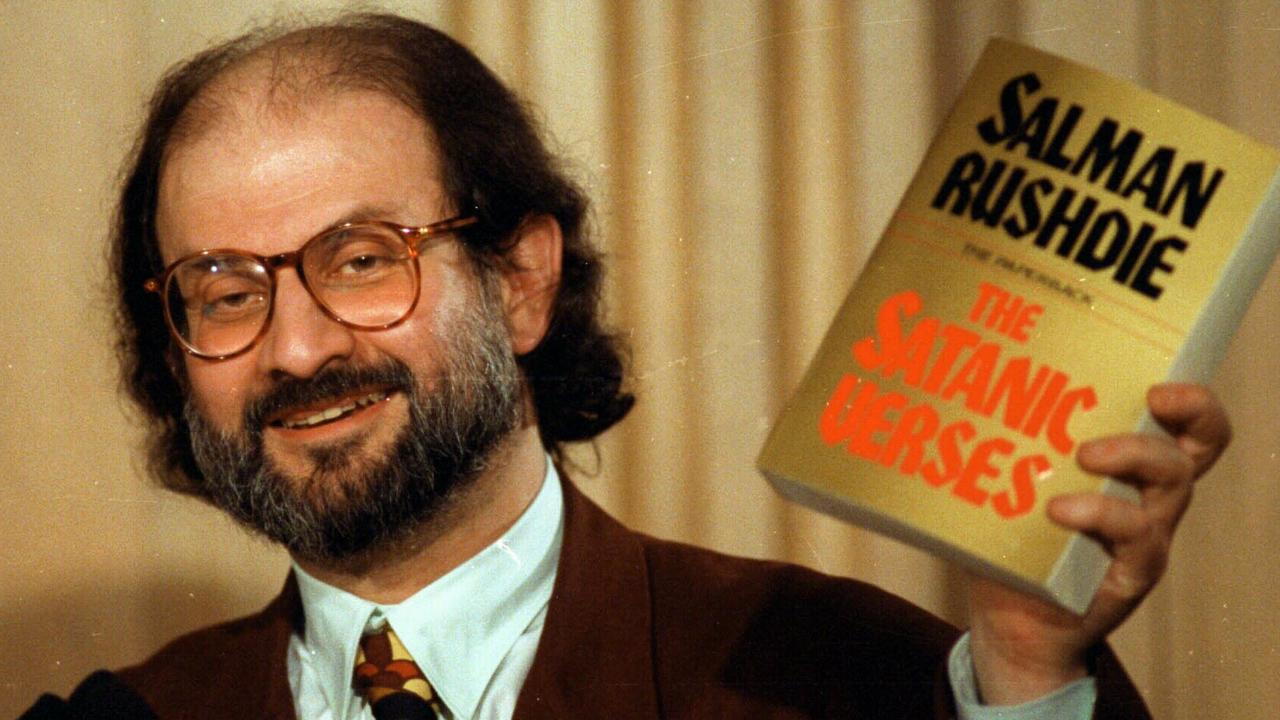 Author Salman Rushdie holds up a copy of his controversial book, The Satanic Verses, in 1992. Picture: Ron Edmonds/AP