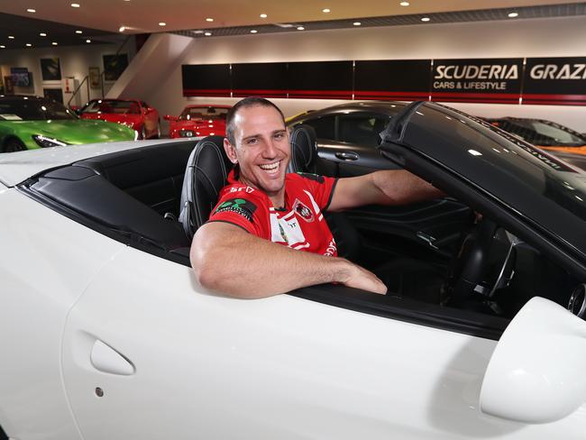 St George rugby league fan Andrew Raptis with a Ferrari which he could potentially buy with the $300,000 Super Coach prize money at the Scuderia Graziani car dealership in Woolloomooloo. Picture: Brett Costello