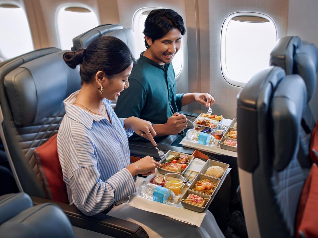 Singapore Airlines premium economy, couple enjoying special meals. Picture - Supplied