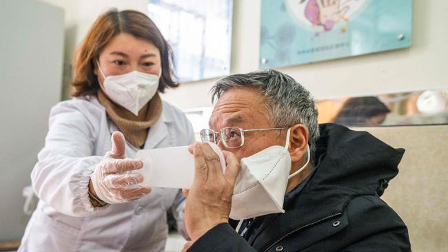 A health worker administers a dose of CanSino Biologics inhalable Covid-19 vaccine in Bijie, in China's southwestern Guizhou province. Picture: AFP