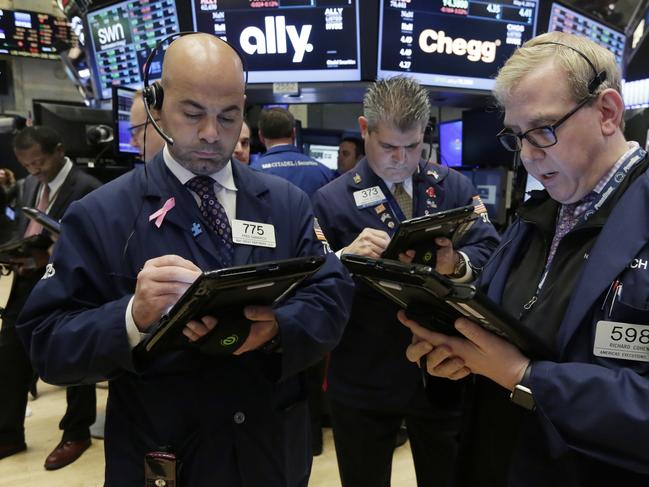 Traders Fred DeMarco, John Panin and Richard Cohen, left to right, work on the floor of the New York Stock Exchange, Wednesday, May 4, 2016. Stocks are opening lower on Wall Street as investors were discouraged by signs of weakness in the U.S. job market and some weak corporate earnings. (AP Photo/Richard Drew)