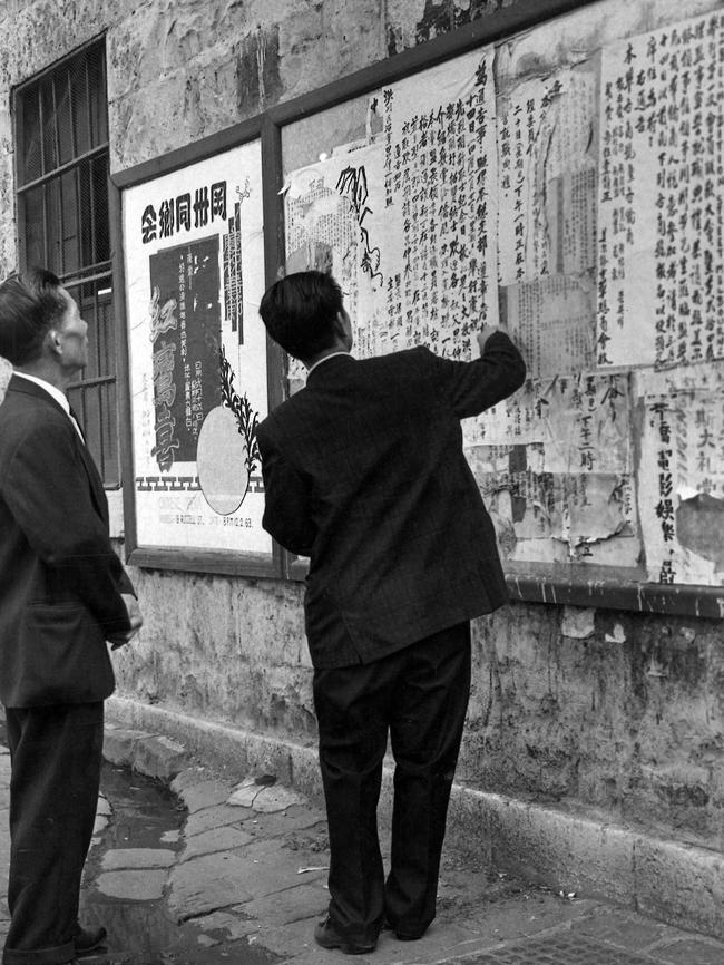 Men reading a bulletin board in a lane off Little Bourke St in 1963. Picture: HWT Library.