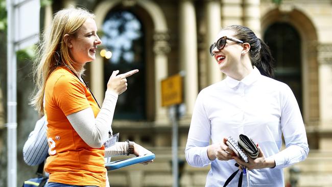 Central Sydney reporter Heather McNab ducks and weaves a charity chugger outside Central Station. Picture: John Appleyard