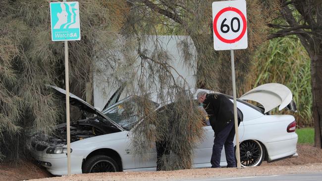 Police examine the victim’s car at Waterloo Corner on Thursday. Picture: AAP/Russell Millard