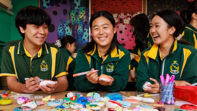 Austin Goserie, 15, Cathy Zhang, 16, and Angela Fu, 14, are members of the school’s art club. The group have been produced rock art for a community garden. Picture: Justin Lloyd.