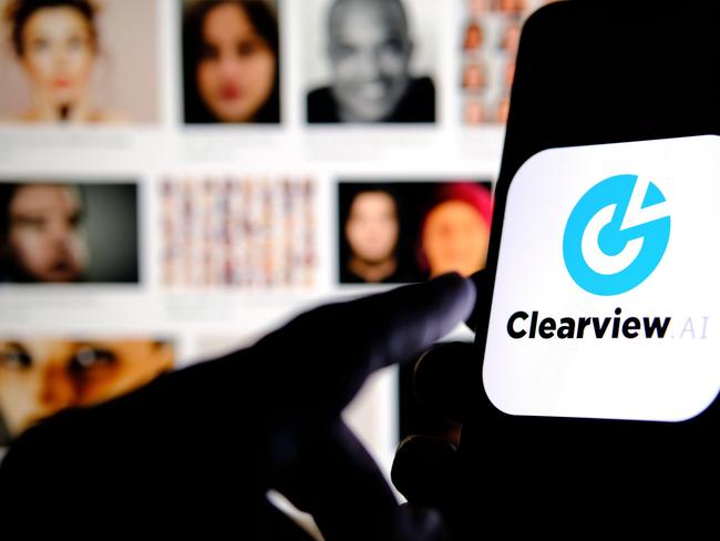 2B1WP59 Clearview AI company logo on the smartphone screen hold in hands with blurred faces on the background. Concept photo for face recognition software. Picture: Alamy