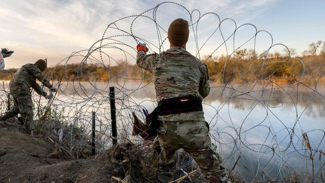 Texas National Guard soldiers install additional razor wire lie along the Rio Grande. (Photo by JOHN MOORE / GETTY IMAGES NORTH AMERICA / Getty Images via AFP)