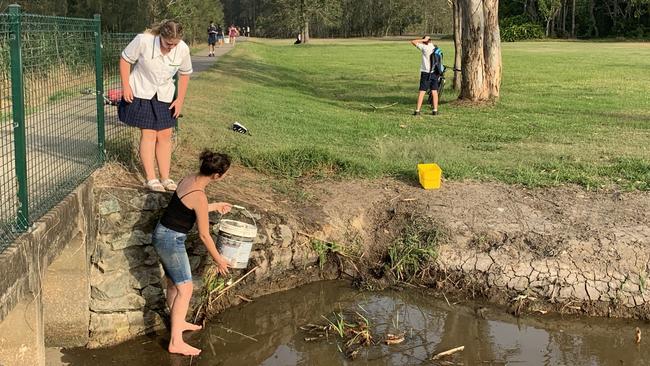 Christine Rington collecting water to help contain the fire. Picture: Emily Halloran.