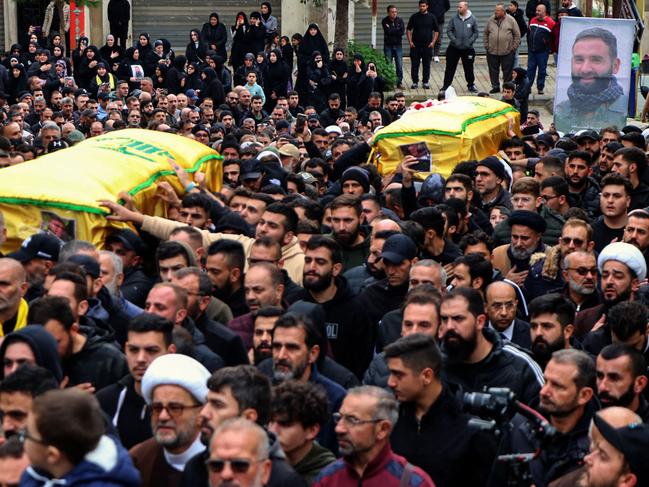 Mourners carry the coffins of a Hezbollah fighter and of one of his relatives who were killed in Israeli bombardment the previous night, during a funeral procession in Bint Jbeil, in southern Lebanon near the border with Israel, on December 27, 2023, amid ongoing cross-border tensions as fighting continues between Israel and Hamas militants in Gaza. An Israeli air strike on a south Lebanon border town killed a Hezbollah fighter, the group said on December 27, with state media reporting two of his relatives were also killed. (Photo by AFP)