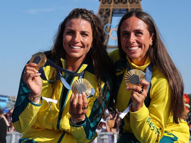 Australia's gold medallists and Jessica and Noemie Fox pose with their medals on stage at the Champions Park at Trocadero during the Paris 2024 Olympic Games in Paris on August 6, 2024, with the Eiffel Tower visible in the background. (Photo by Jack GUEZ / AFP)