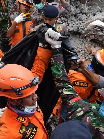 Members of a search and rescue team carry the body of a quake victim found among the rubble in Bangsal, northern Lombok. Picture: Adek Berry/AFP