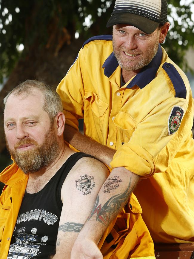 Rodney and Darryl McSorley show off their fresh firefighter tattoos.