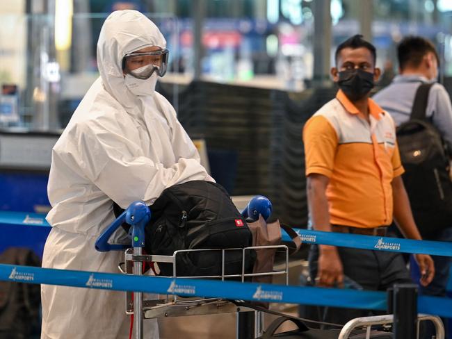 A passenger wearing personal protective equipment queues to check-in for a flight at the Kuala Lumpur International Airport. Picture: AFP