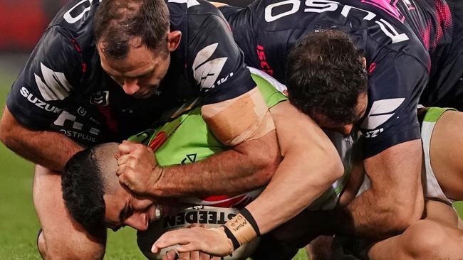 Cameron Smith holds the ears of Canberra’s Bailey Simonsson at AAMI Park. Picture: AAP