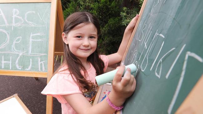 Coco, 6 practises her writing using chalk. Picture: Tim Carrafa