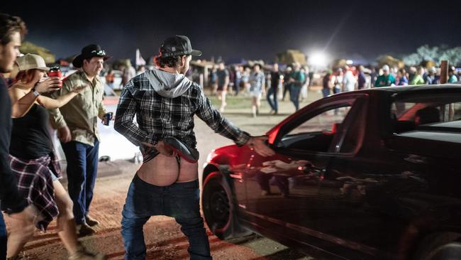 A festivalgoer shows his behind to passing traffic. Picture: James Gourley/Getty Images