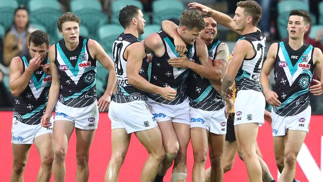 Peter Ladhams is congratulated by his teammates after kicking a goal on debut for the Power. Picture: Scott Barbour (Getty).