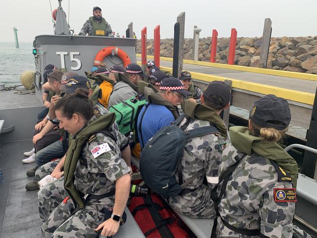 CFA volunteers board one of HMAS Choules Landing craft as they depart Mallacoota. Picture: AAP