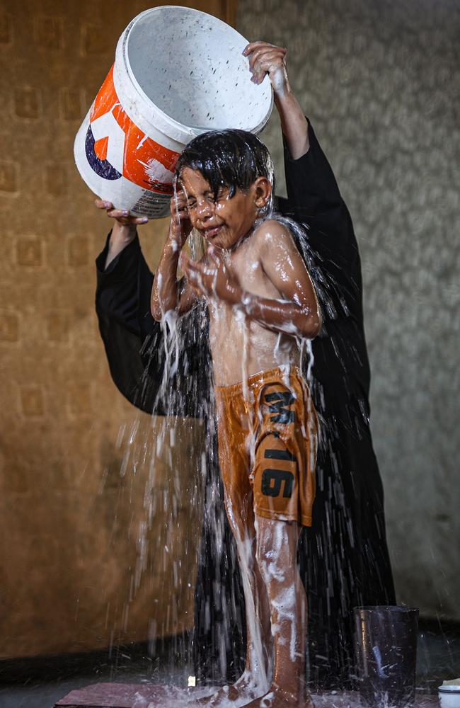 A child is given a shower to cool off during a very hot summer at al-Nasr neighbourhood in Gaza City. Picture: Mustafa Hassona/Anadolu Agency via Getty Images