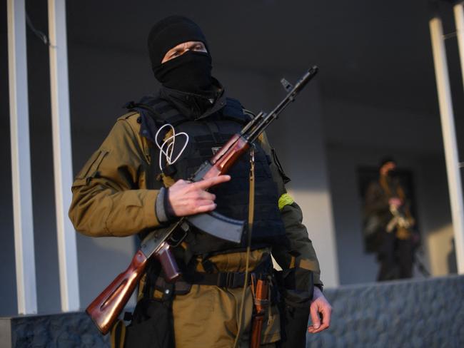 Armed civilian volunteers stand alert on a street in Kyiv. Picture: AFP.