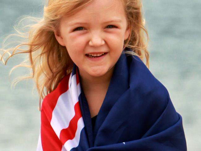 HOLD FOR AUSTRALIA DAY PAGE 1. Daily Telegraph. Australia Day; Asha Olsen, 5 yrs, wrapped in an Australian flag on Horseshoe Beach in Newcastle.