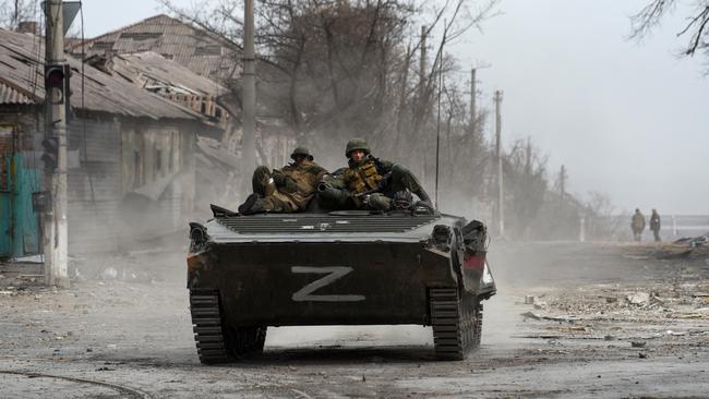 Russian troops sit atop an armoured vehicle in the southern port city of Mariupol.