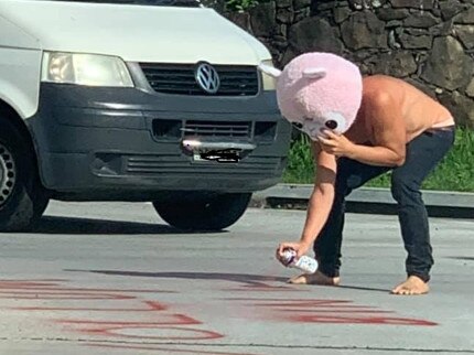 A man seen spray-painting graffiti onto a Byron Bay road.