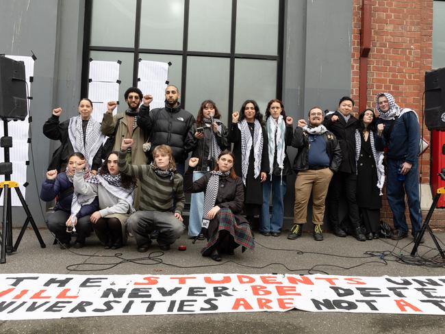 Fourteen of the students facing misconduct hearings raise their fists to show ‘solidarity’. Picture: Jason Edwards