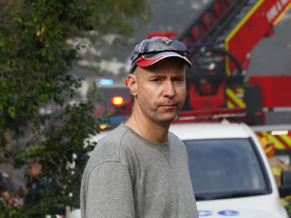 David Topp looks on as fire crews battle multiple house fires in Evelyn Street in Grange on Saturday. Photo: David Clark.