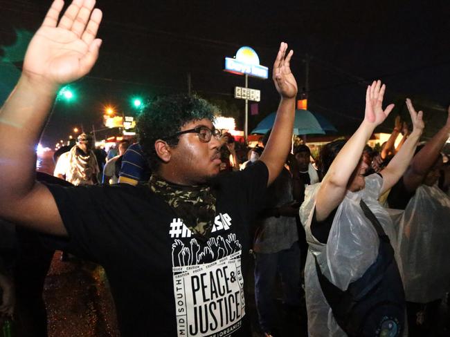 DO NOT PUBLISH THIS PHOTO WITHOUT SPEAKING WITH STEVE MOORHOUSE - LEGAL ISSUES. GUNS IN AMERICA - RAMAGE. Memphis Black Lives matter Protest: Protestors yell at Police, "Hands up-don't shoot". Police form a barricade to prevent Black Lives Matter protestors surging into Graceland, Memhis, on the 39th anniversary of the death of Elvis Presley. Present are members of the New Black Panther Party, who berate black police officers standing guard as murderers and traitors to their race. Picture: Gary Ramage