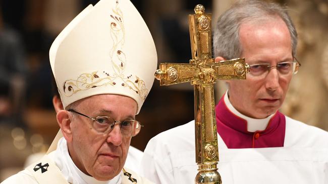 Pope Francis (L) leaves after leading the episcopal ordination mass in St. Peter’s basilica at the Vatican on April 22, 2018. / AFP PHOTO / VINCENZO PINTO