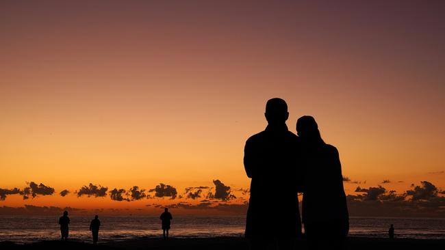 People commemorate Anzac Day at dawn on Currumbin Beach on the Gold Coast. Picture: Dave Hunt