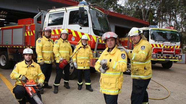 Members of the NSWRFS Horsley Park Rural Fire Brigade pose for a photo with specialty equipment and their ‘two heavies’. (AAP Image / Robert Pozo).