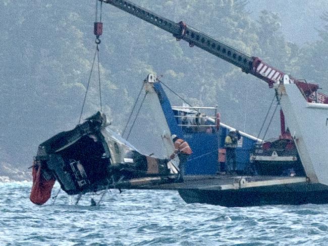 A barge anchored at the site where a MRH 90 military helicopter crashed, lifts out the tail section. Picture: Michaela Harlow