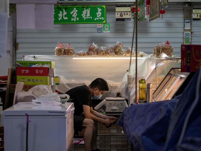 A vendor waits for customers at his stall at a market in Beijing.